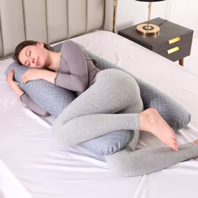 La almohada de una mujer embarazada apoya el cuerpo en forma de U para dormir noche