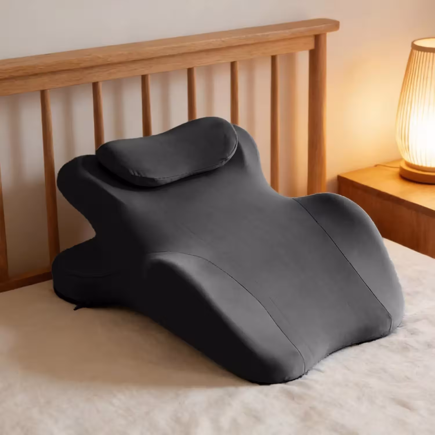 Ergonomic pillow for reading in bed and watching TV, a gray-colored wedge-shaped pillow.